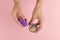 Hands of a girl holding a powder and a beauty blender for makeup on a pink background, copy space