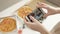 Hands of girl with smartphone taking picture of delicious pizza