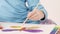 Hands of girl watercolor painting butterfly on table in room, close up