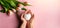 In the hands of a girl, a white heart on a pink background and tulips on the table. Top view with free space for your inscription