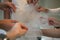 Hands of girlfriends helping the bride to dress her dress