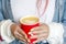 Hands girls with bright summer manicure holding a red Cup of coffee with a painted heart.