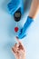 Hands of gloved doctor with glucometer taking blood sugar reading from caucasian woman