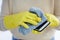 Hands, gloves and cleaning phone screen of germs, bacteria with alcohol wipe or dust cloth. Covid, disinfection and