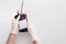 Hands in gloves holding blood pack for transfusion on white background