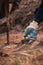 Hands in gloves planting small tree sprout in soil