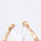 Hands in gold gloves hold rabbit mask in white minimal space. Fashion festive Christmas / New Year holidays party celebration