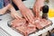 hands. granddaughter helps grandfather cook barbecue and puts the meat on grill