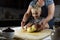 Hands of a grandmother and a child hold a dough together