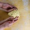 Hands of a grandmother and a child hold a dough together