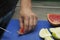 Hands of a grapefruit cutting chef