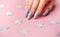 Hands with grey manicure on a pink background
