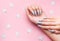 Hands with grey manicure on a pink background