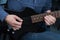 Hands of guitarist with an electric guitar pick. Abstract music background