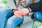 The hands of a guy and a girl. A loving couple are sitting on a blanket and holding hands in the winter