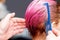 Hands of hairdresser are combing pink hair