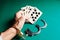 Hands in handcuffs holding playing cards on a colored background