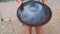 Hands with hang drum close up, man practicing native music traditional drumming instrument played with hands. near water