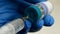 Hands of healthcare worker in protective gloves draw Covid-19 coronavirus vaccine into new disposable syringe from glass