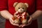 hands hold a cuddly teddy with a big red bow ready to hand it over, generative AI