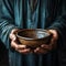 Hands hold empty bowl, portraying the harshness of hunger and economic hardship