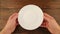 Hands hold an empty white plate