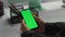 Hands hold green smartphone in office closeup. Businessman checking messages