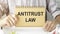 hands hold notepad with Antitrust law text