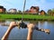 Hands hold rope swing before jump into the water on the lake and mansion hous background