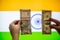 Hands holding an american dollar of united states of america and indian rupee in front of an indian flag comparing the