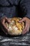 Hands holding appetizing round bread with white powder