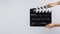 Hands is holding black Clapperboard or movie slate. it use in video production ,film, cinema industry on white background