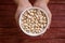 Hands holding black eyed beans in white bowl