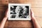 Hands holding black-and-white photo of senior couple in picture