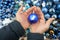 Hands holding blue color ball with mouse symbol of the new year 2020 in christmas decoration shop. Xmas shopping. Choosing toys