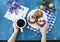 Hands holding a blue cup.Breakfast with biscuits and fresh berries.