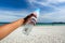 Hands holding bottle in front of beautiful azure sea