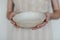 Hands holding ceramic bowl isolated on white background. Handmade ceramic tableware and pottery