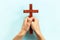 Hands holding christian wooden cross. Faith and prayer concept