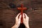 Hands holding christian wooden cross. Faith and prayer concept