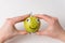 Hands holding cute little Apple with Googly eyes and drawn smile. Apple haracter on white background