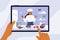 Hands holding digital tablet with young chef woman on screen preparing healthy food in kitchen