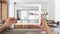 Hands holding and drawing on tablet showing japandi kitchen and dining room details CAD sketch. Real finished interior in the