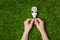 Hands holding energy saving eco lamp over grass
