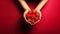 Hands holding fresh strawberries on a red background. Healthy food concept.