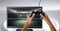 Hands holding gaming controller with sports arena stadium score on television