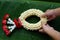 Hands holding a garland made of jasmine and roses on banana green leaves special celebration