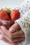 Hands holding glass of strawberries