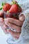 Hands holding glass of strawberries