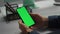 Hands holding green smartphone closeup. Office employee checking stock market